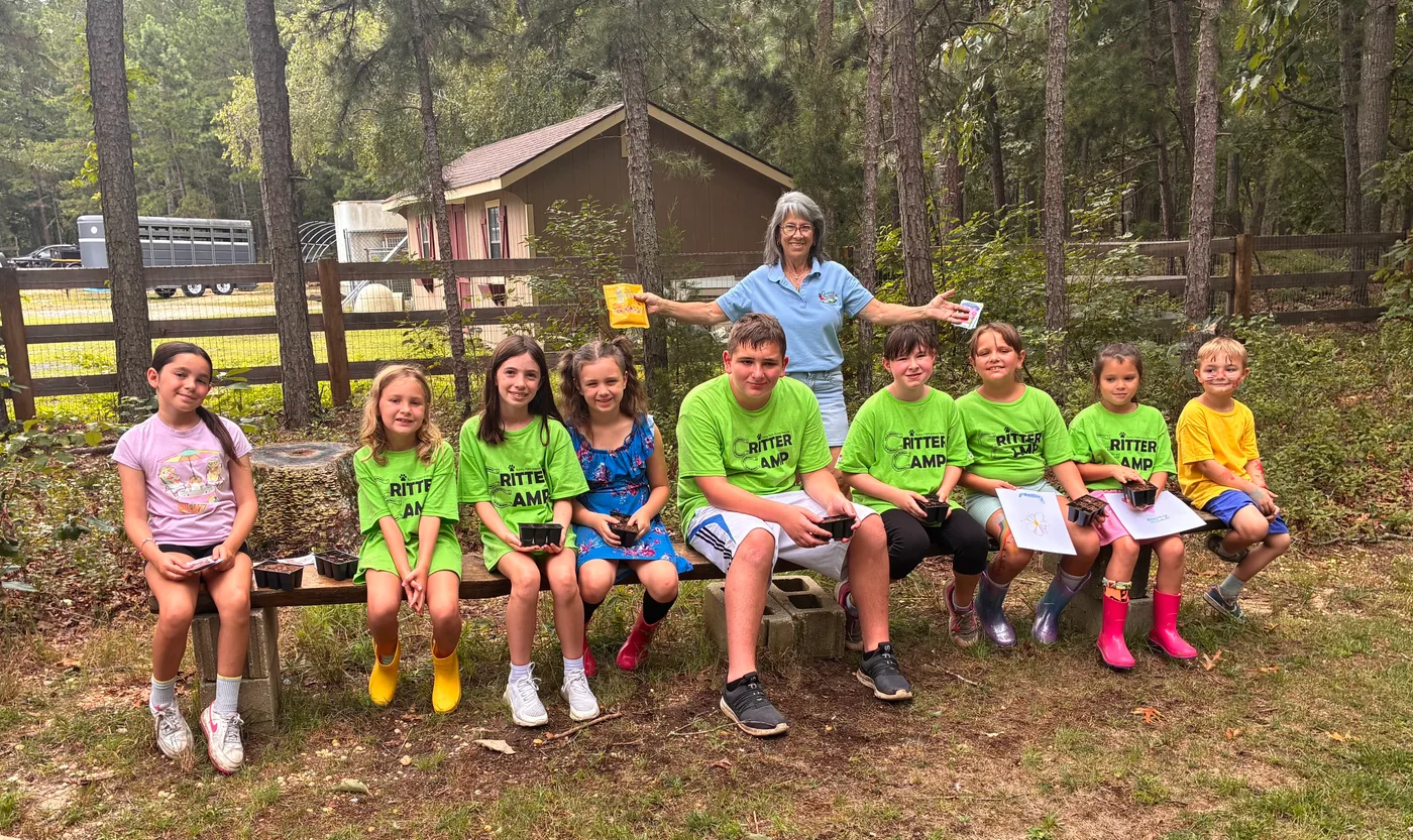 The Critter Camp group sitting together on the bench outside the pavilion