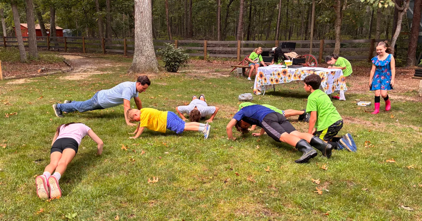 Campers dropping down for pushups on the grass