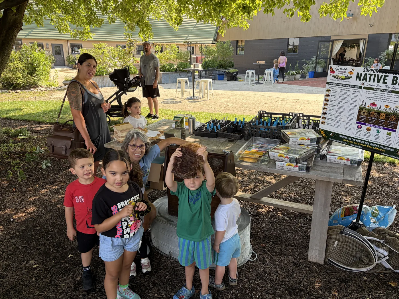 Children at the display table in front of the native bees banner