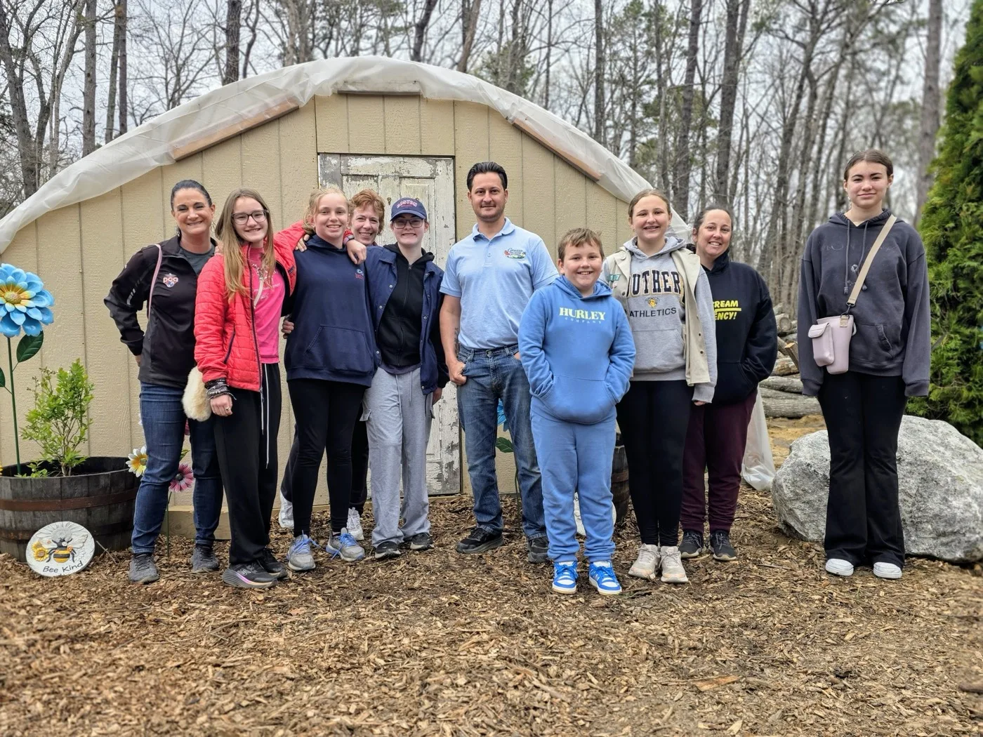 Don Grasso with a local Girl Scout troop and their leaders in front of the greenhouse on Bee Day