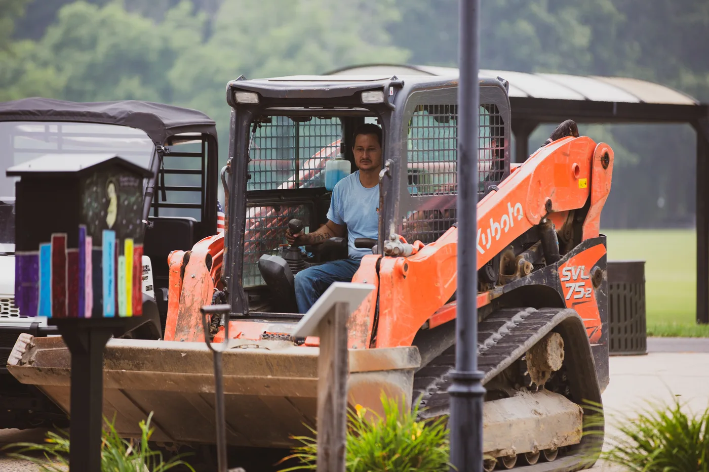 Founder Don Grasso operating a compact track loader to move soil for the new pollinator beds