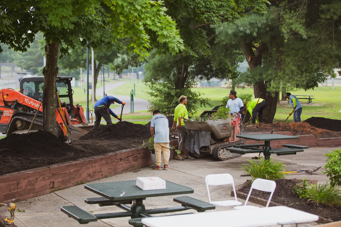 A wide view of the work in progress, picnic tables, equipment and volunteers spread across the site