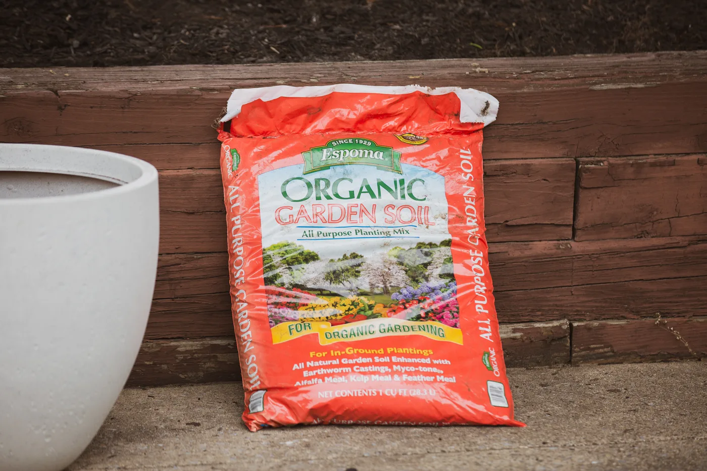 A bag of organic garden soil against the wall beside the new bed